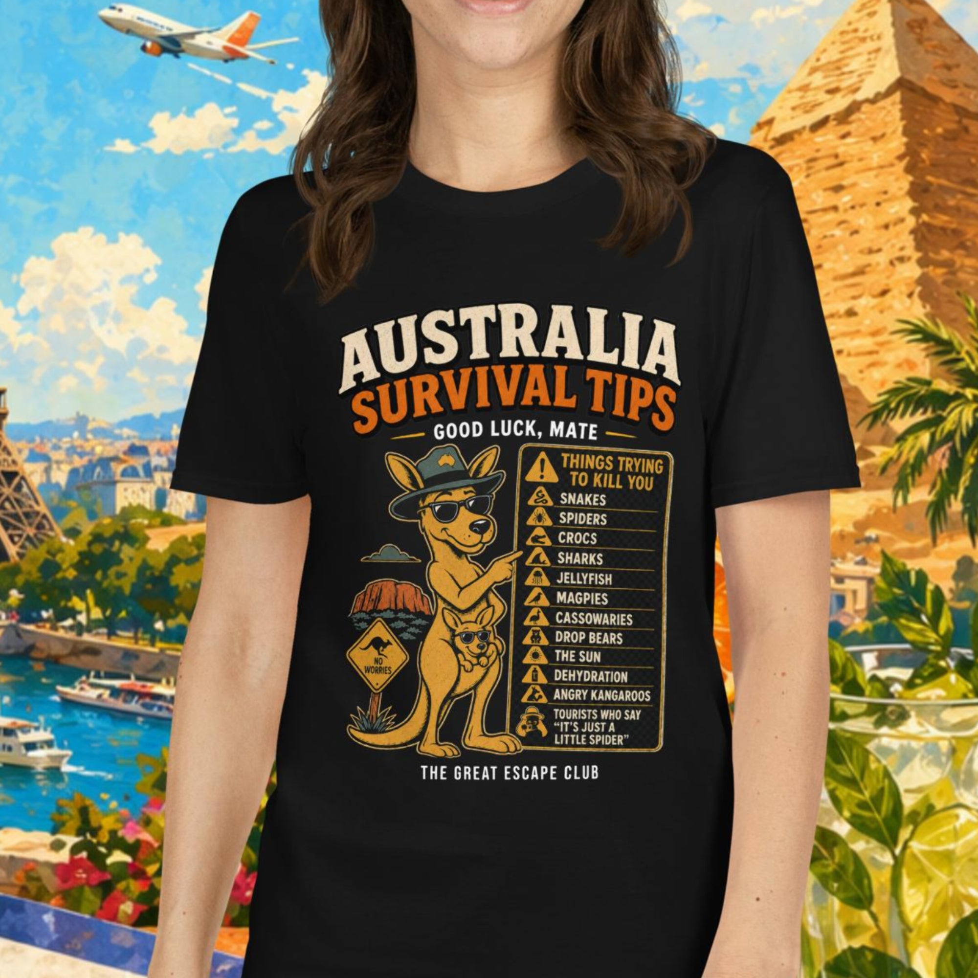 Woman wearing a black t-shirt with 'Australia Survival Tips' design, standing in front of a colorful background with landmarks and tropical elements.