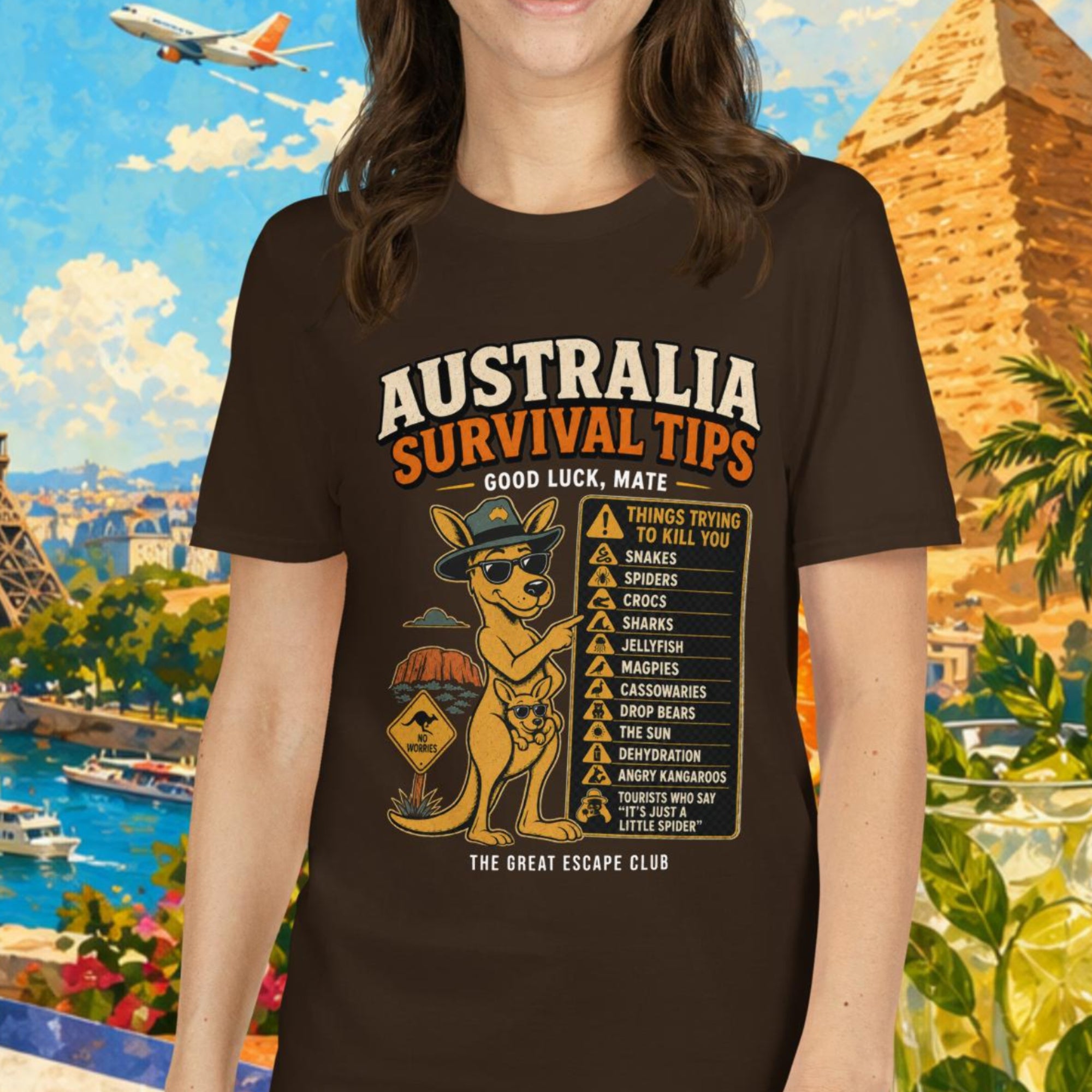 Woman wearing a 'Australia Survival Tips' t-shirt with a colorful background featuring landmarks and tropical elements.