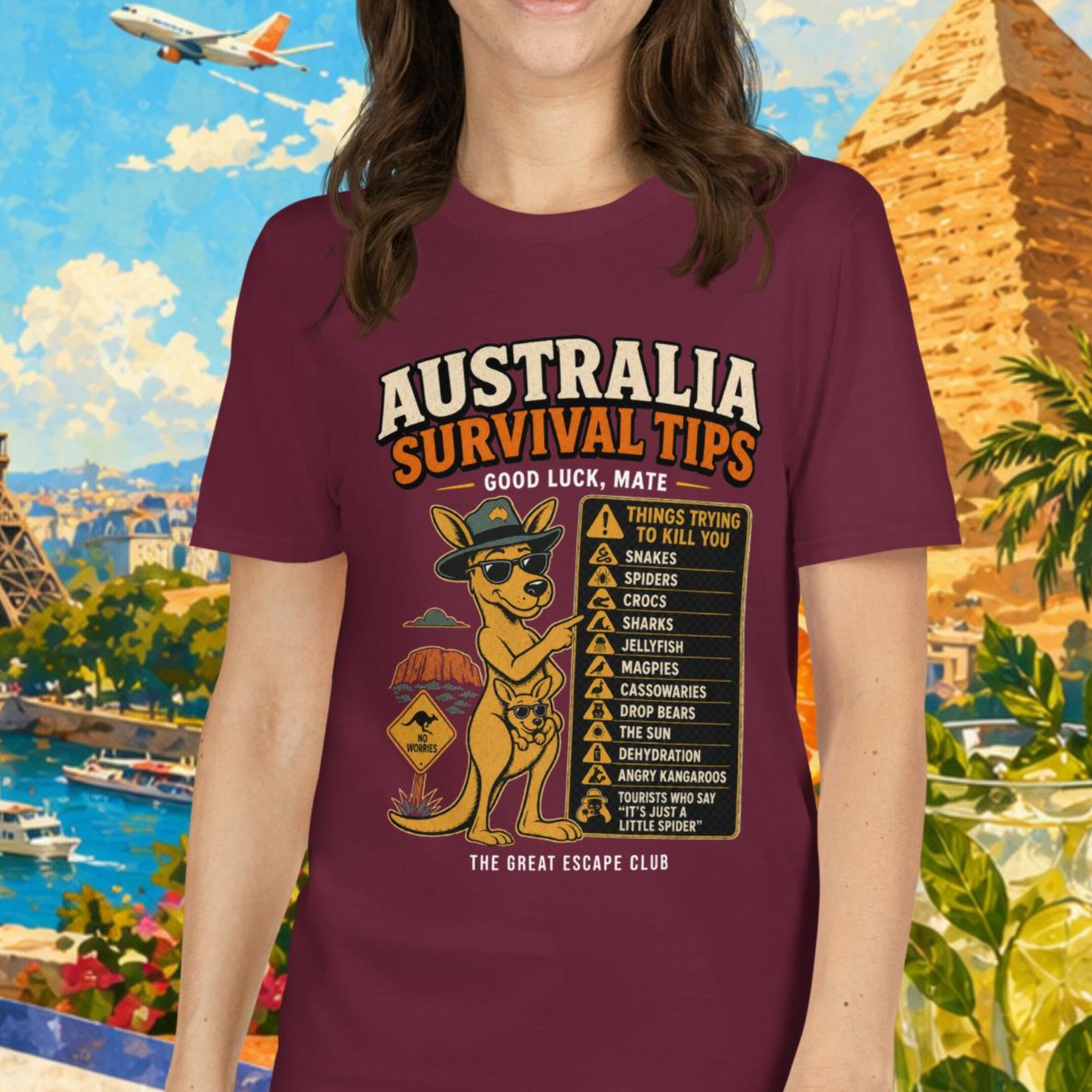 Woman wearing a 'Australia Survival Tips' t-shirt with a colorful background featuring landmarks and tropical elements.