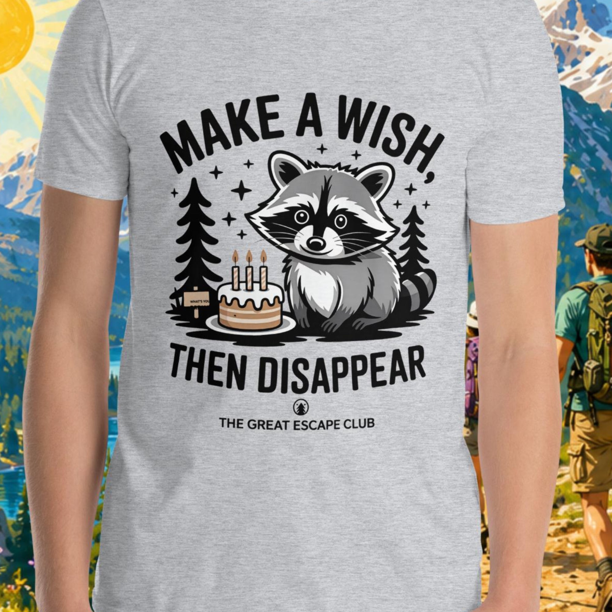 Person wearing a t-shirt with a raccoon graphic and text in a mountainous landscape