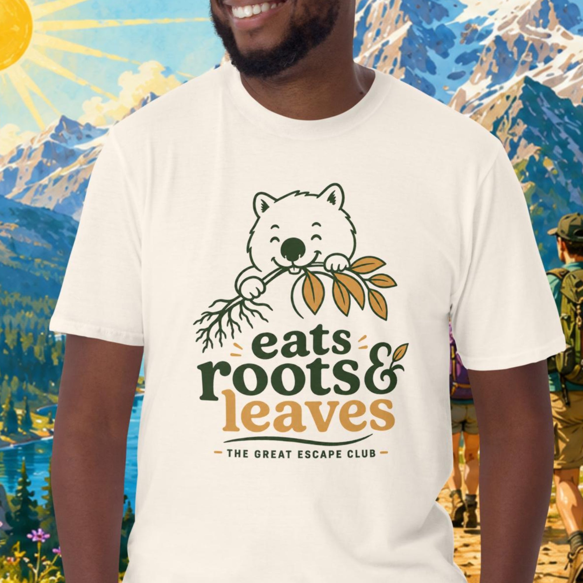 Man wearing a t-shirt with 'eats roots & leaves' design in a mountainous outdoor setting.