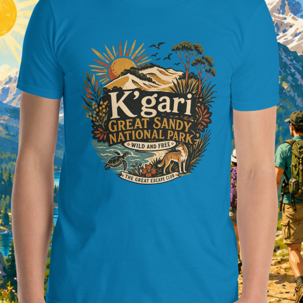 Person wearing a blue t-shirt with K'gari Great Sandy National Park design, set against a scenic mountain backdrop.