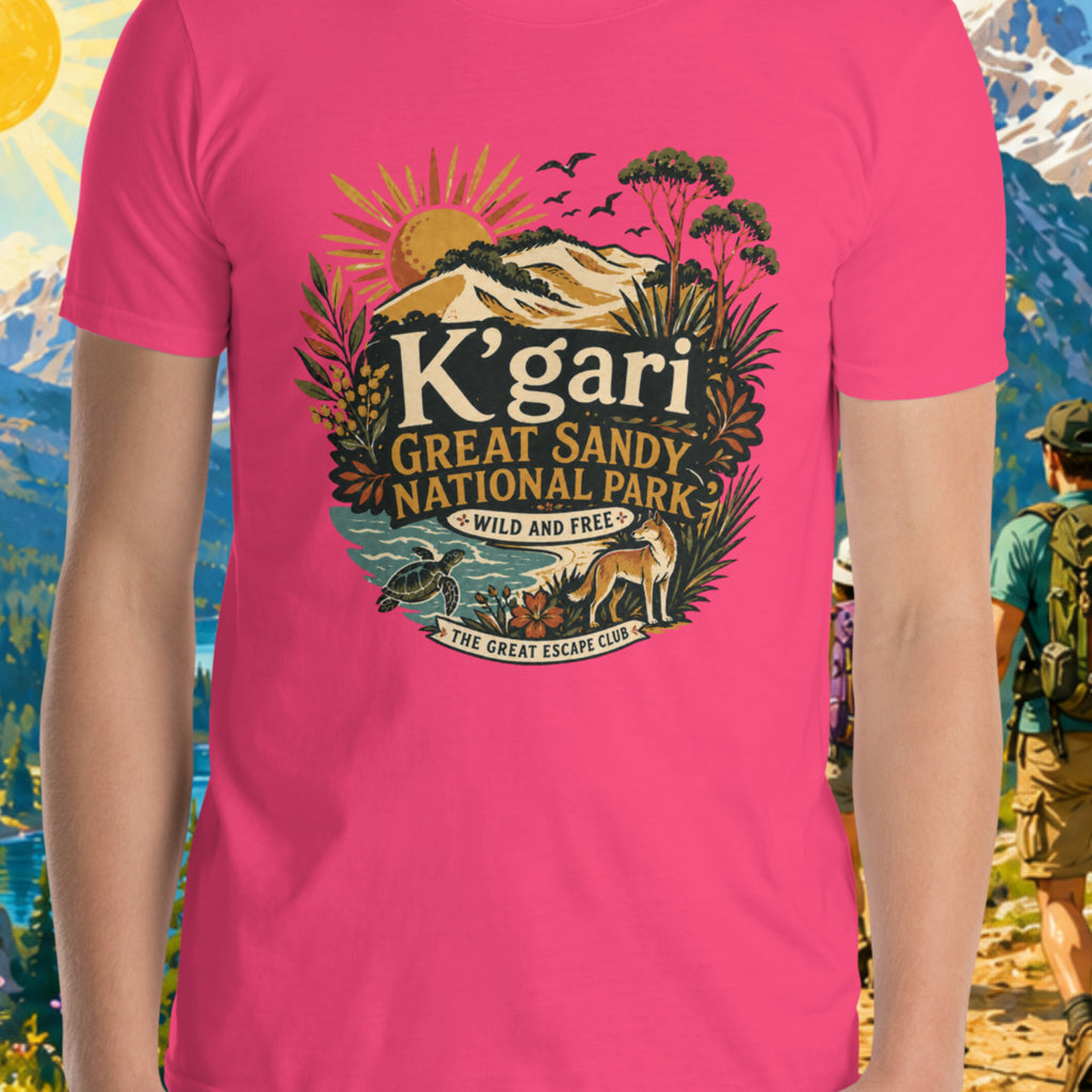 Person wearing a pink t-shirt with K'gari Great Sandy National Park design against a scenic mountain backdrop.