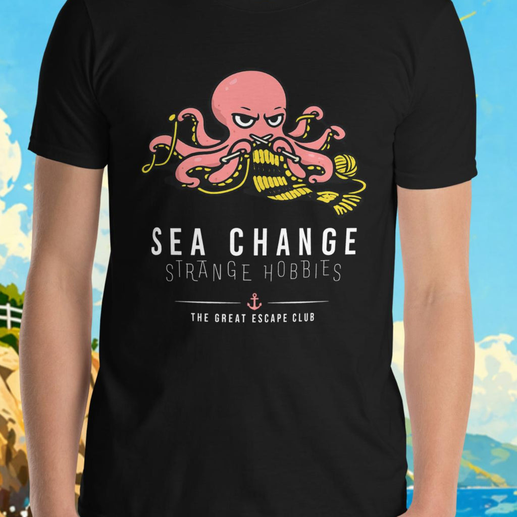 Person wearing a black t-shirt with an octopus design and text, standing in front of a scenic background with a lighthouse and sailboat.