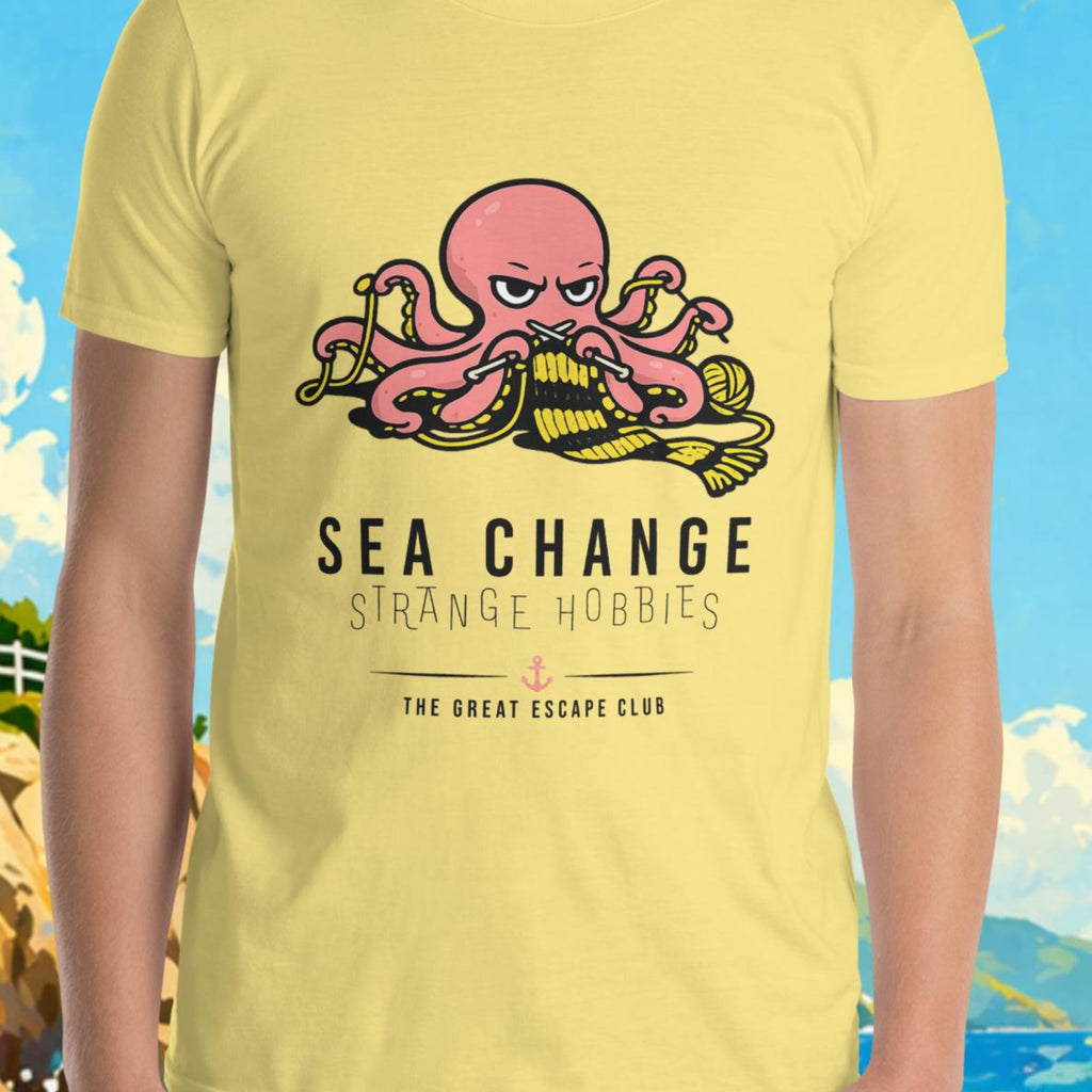 Person wearing a yellow t-shirt with a graphic design in front of a scenic background with a lighthouse and sailboat.