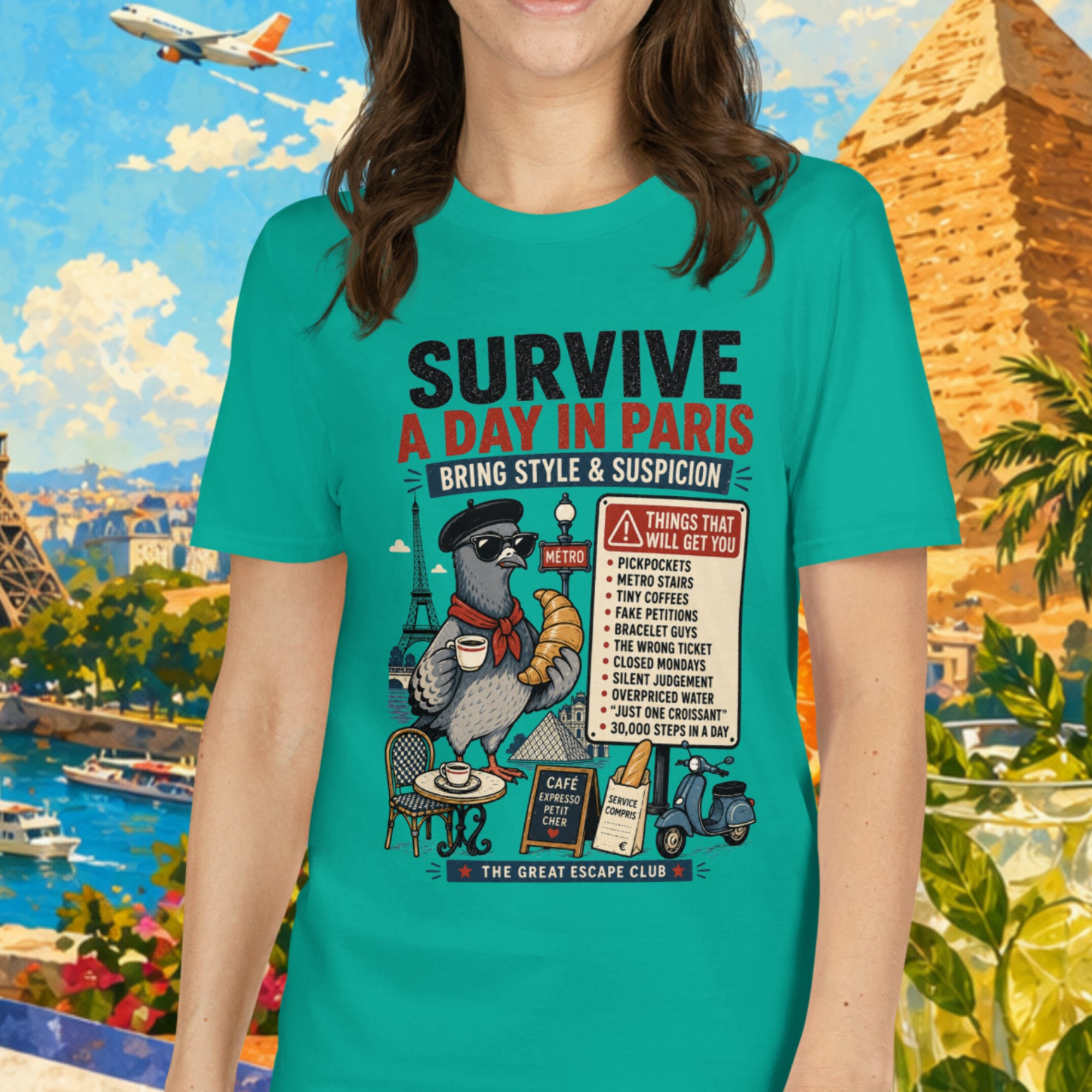 Woman wearing a teal t-shirt with a graphic design in front of a colorful background with landmarks and tropical elements.