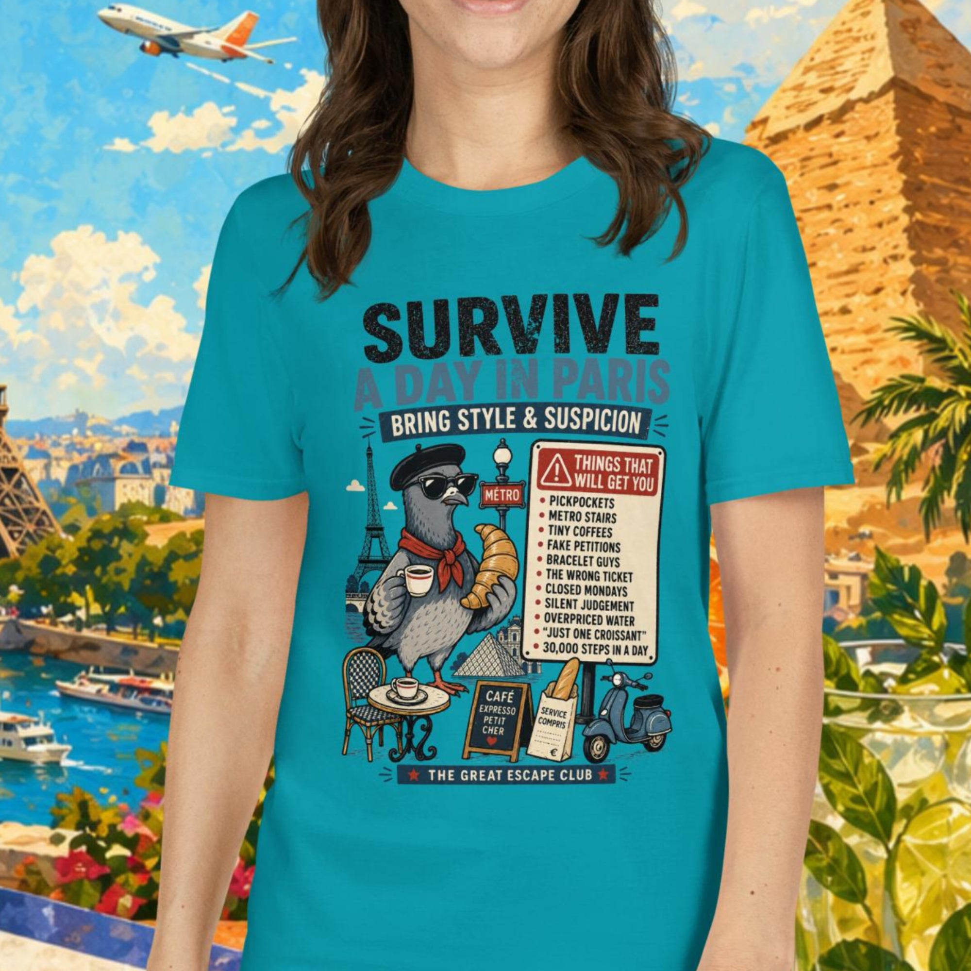 Survive a Day in Paris unisex T-shirt in tropical blue featuring a funny Paris pigeon travel graphic with croissant, espresso and warning sign design.