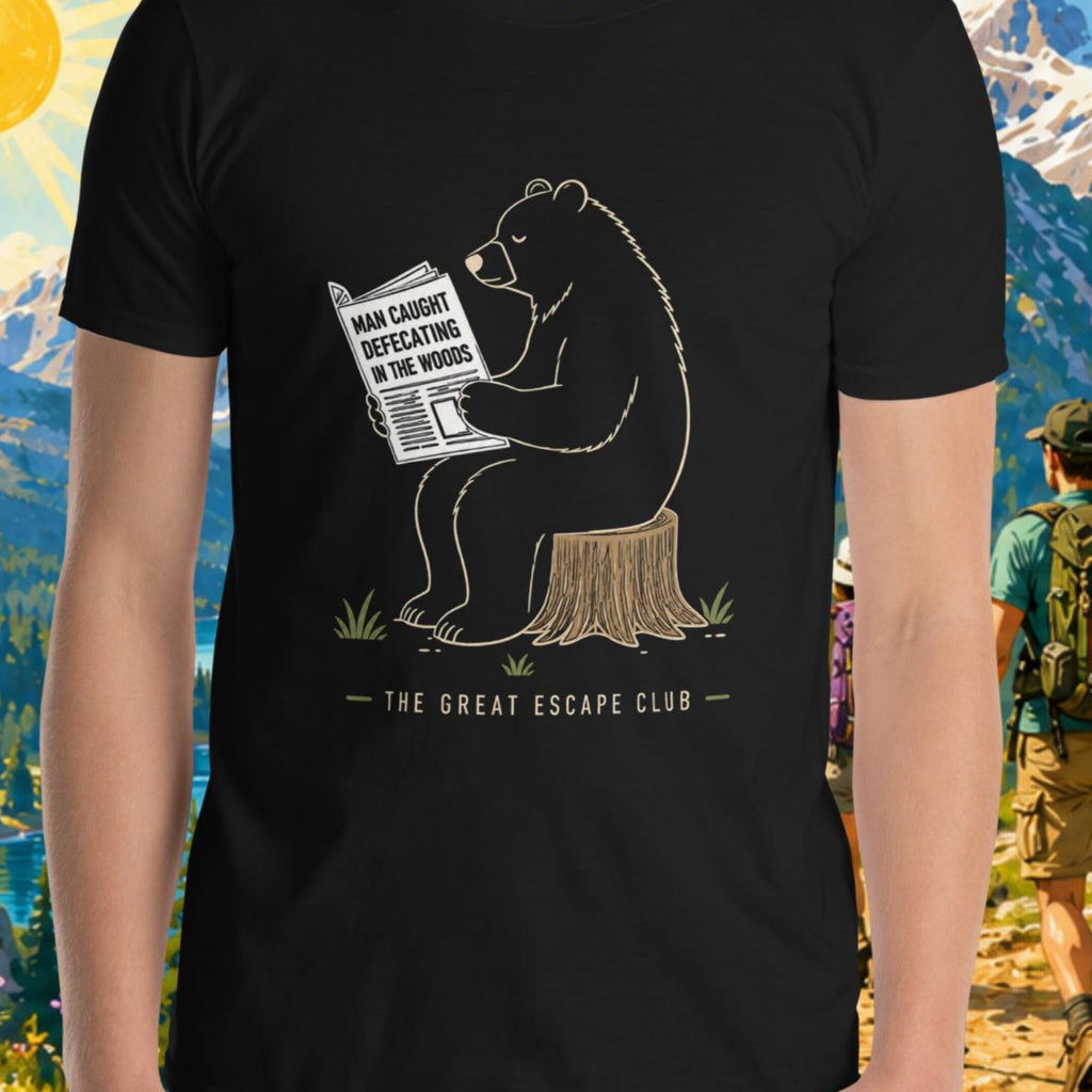 Person wearing a t-shirt with a bear graphic and text, standing in front of a scenic mountain backdrop.