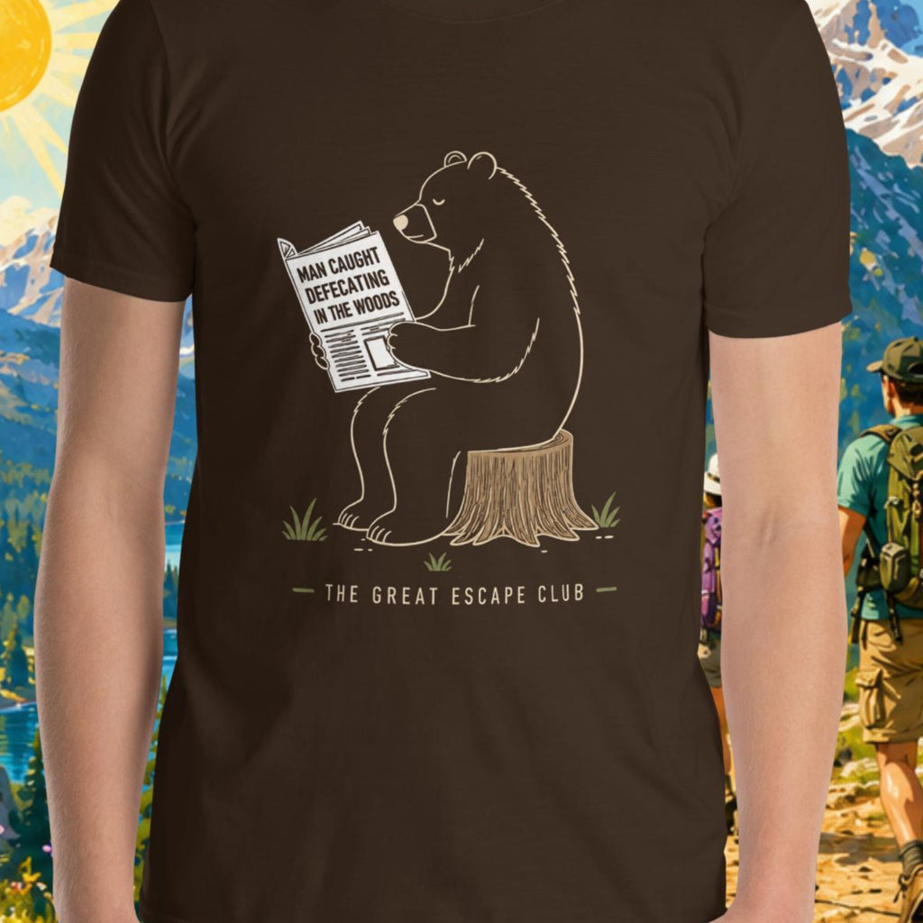 Person wearing a t-shirt with a bear graphic and text, standing in front of a scenic mountain backdrop.