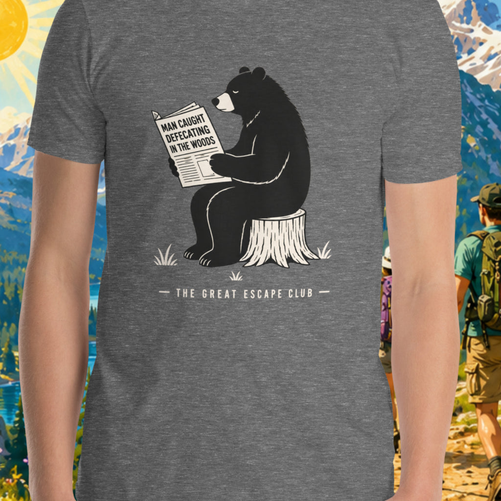Gray t-shirt with a bear reading a newspaper graphic and 'The Great Escape Club' text, worn by a person in a forest setting.