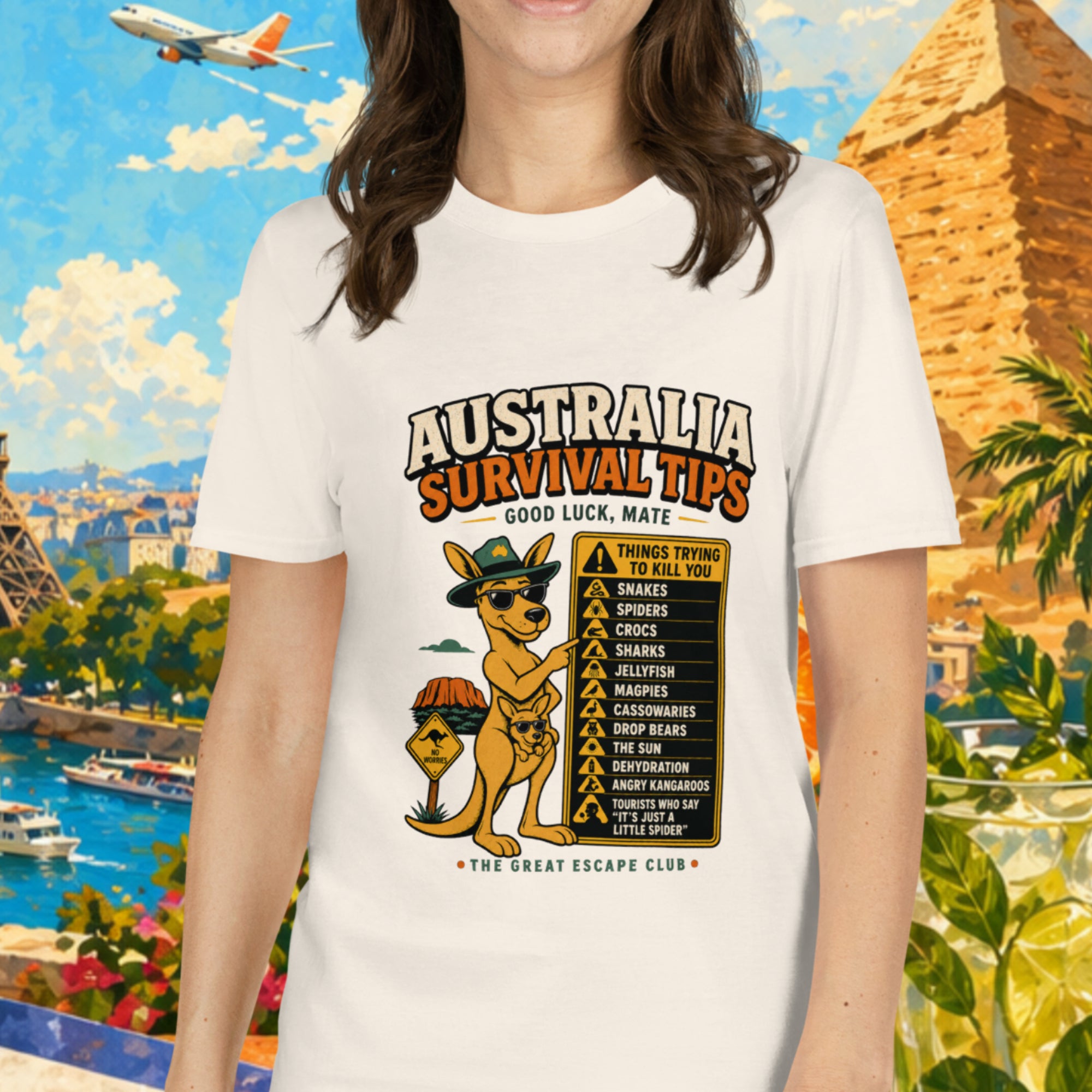 Woman wearing a t-shirt with Australia survival tips graphic in front of a colorful travel-themed background.