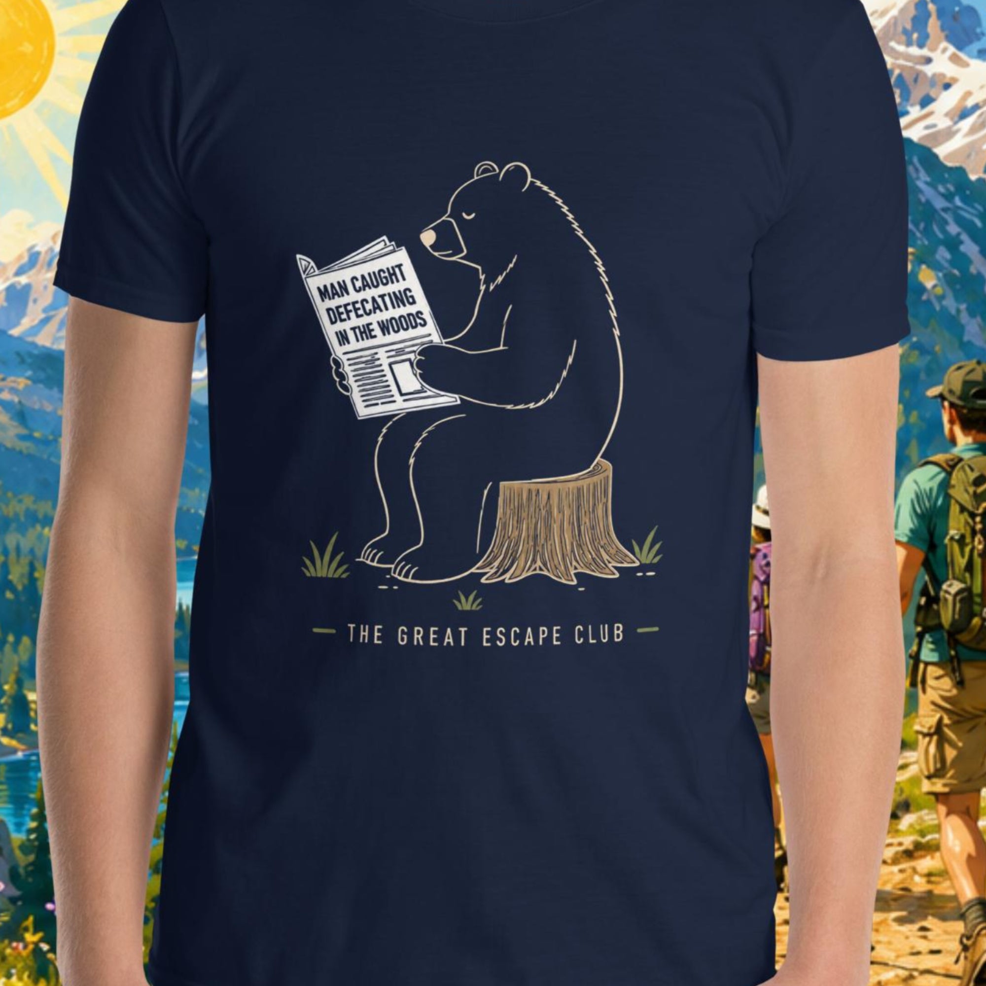 Person wearing a navy blue t-shirt with a bear graphic and text, standing in front of a scenic mountain backdrop.