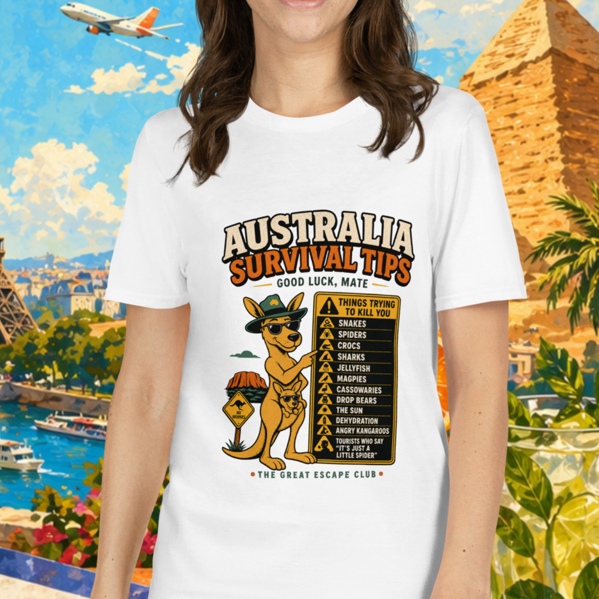 Woman wearing a white t-shirt with 'Australia Survival Tips' design, standing in front of a colorful travel-themed background.