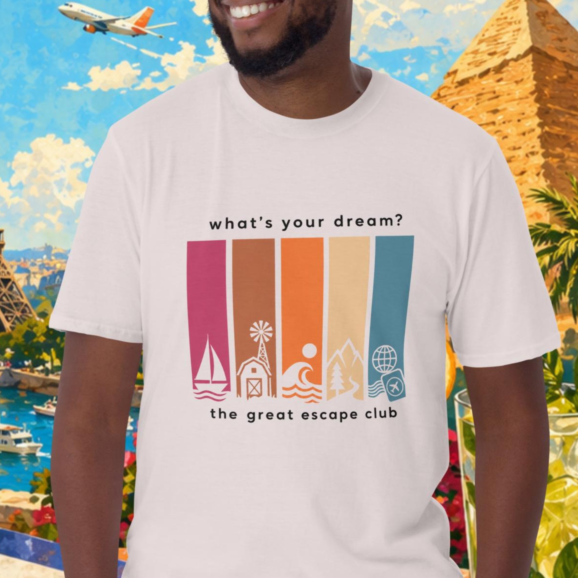Man wearing a t-shirt with travel-themed design in front of a colorful background with landmarks and travel items.