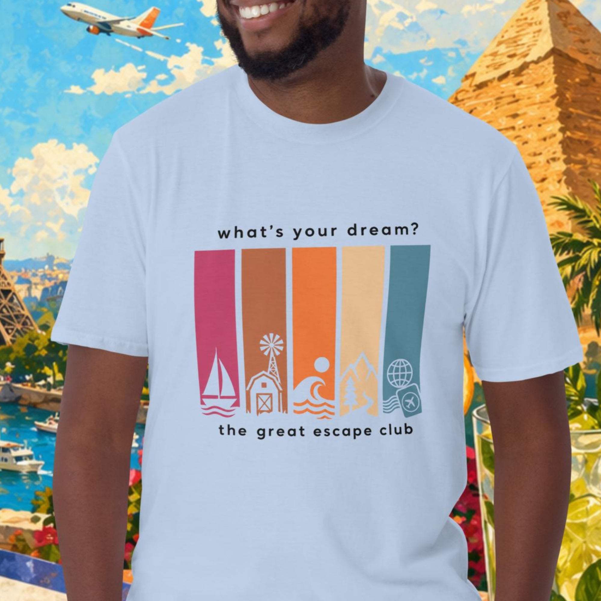 Man wearing a t-shirt with travel-themed design in front of a colorful background with landmarks and travel items.
