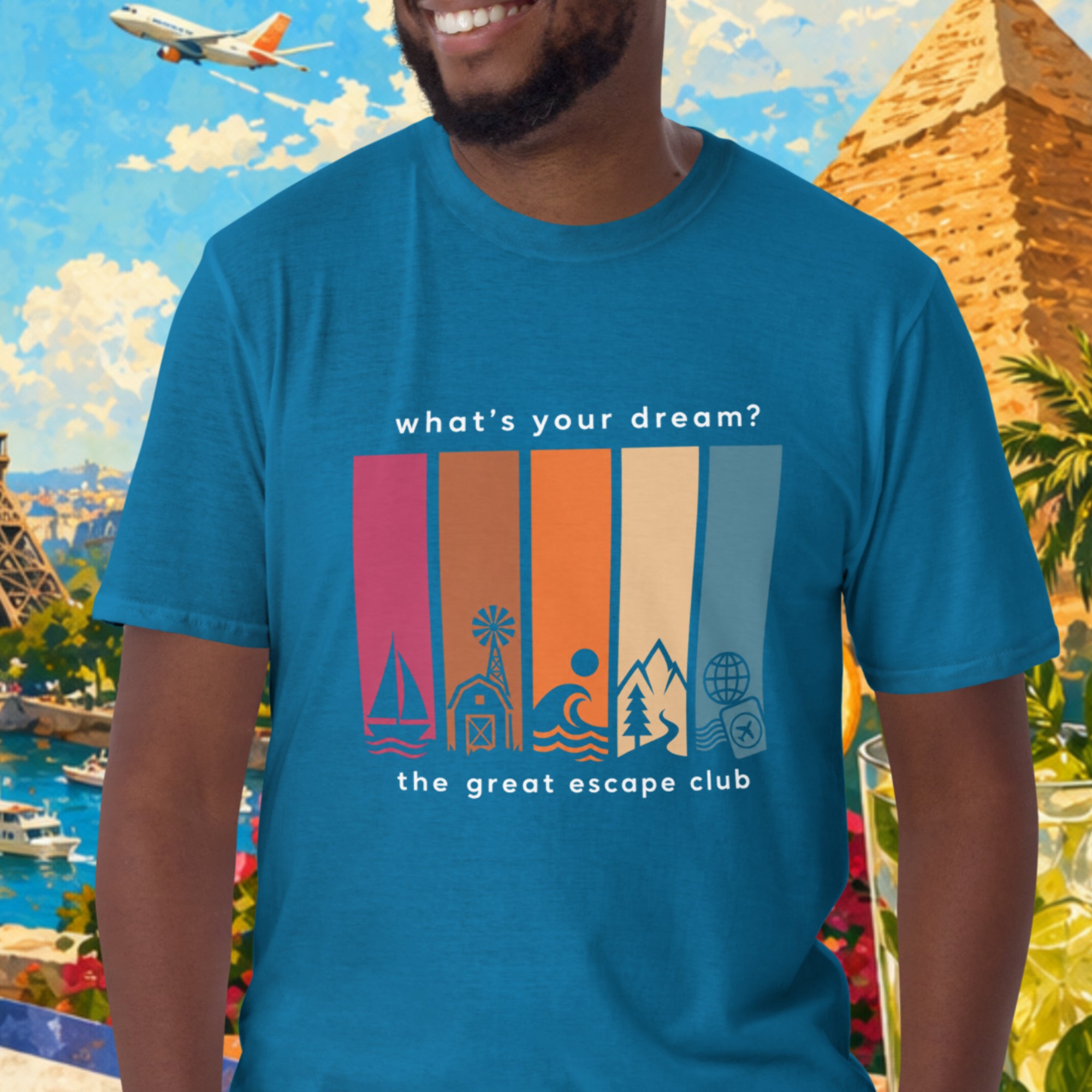Man wearing a blue t-shirt with a travel-themed design in front of a colorful background with landmarks and nature.